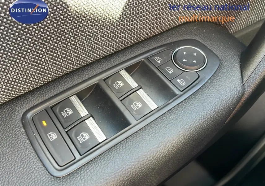 Gros plan sur les commandes des vitres côté conducteur du Renault Captur E-Tech gris rafale avec toit noir, intérieur tissu gris.