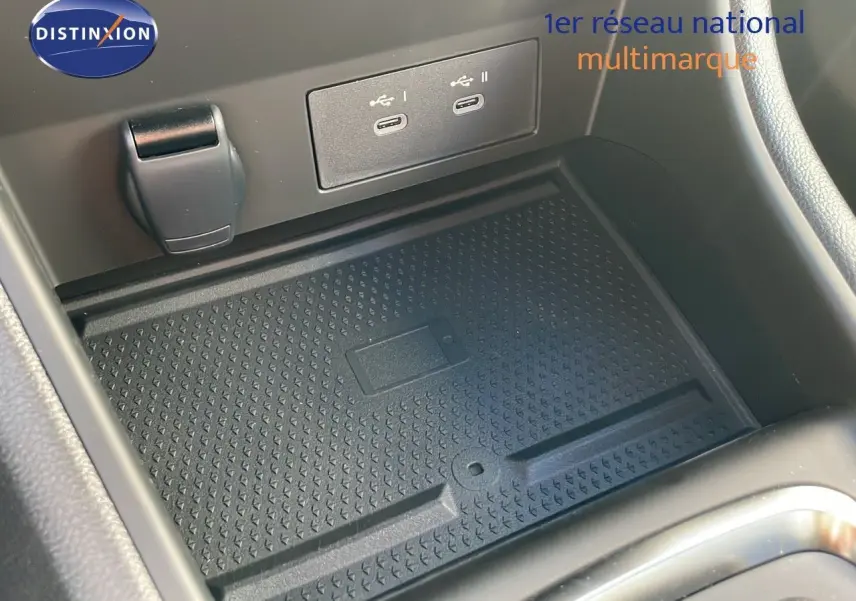 Gros plan sur le chargeur sans fil et ports USB dans la console centrale du Renault Captur gris Rafale 2025.