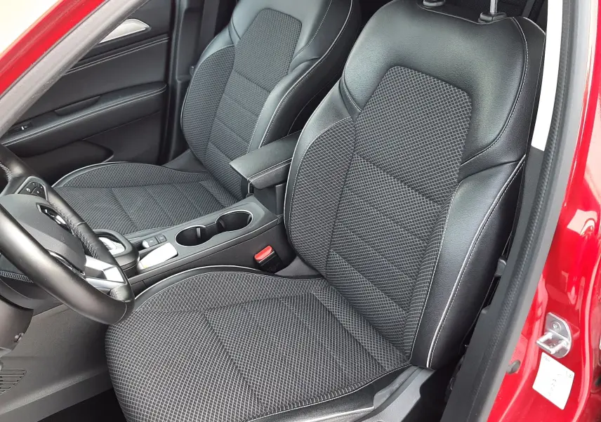 Vue intérieure côté gauche du Renault Arkana rouge Flame 2021, sièges avant en cuir et tissu noir avec surpiqûres blanches.