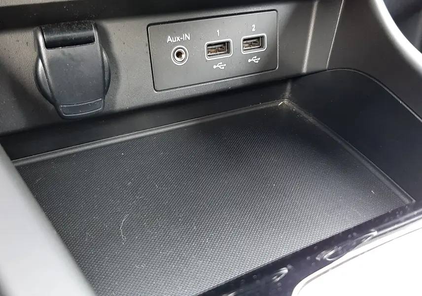 Gros plan sur la console centrale du Renault Arkana 1.6 E-TECH 145 Intens, montrant les ports USB et l'entrée Aux-In.