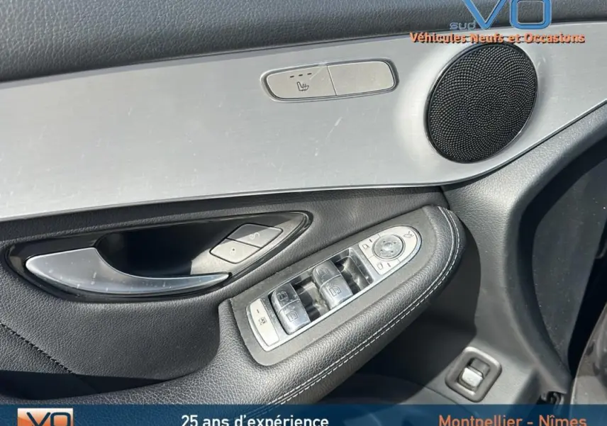 Gros plan sur la porte avant gauche du Mercedes GLC gris anthracite, avec commandes de vitres et haut-parleur intégré.