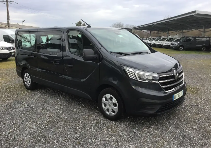 Renault Trafic Combi gris comète vu en 3/4 avant droit, véhicule utilitaire avec grandes vitres latérales.