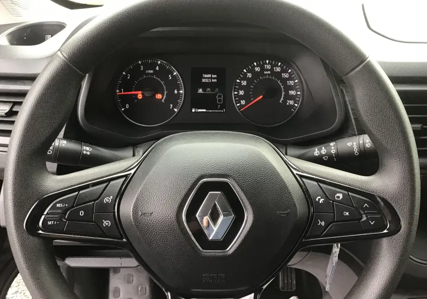 Vue rapprochée du volant noir de Renault Trafic Combi 2022 avec commandes multifonctions et tableau de bord digital.