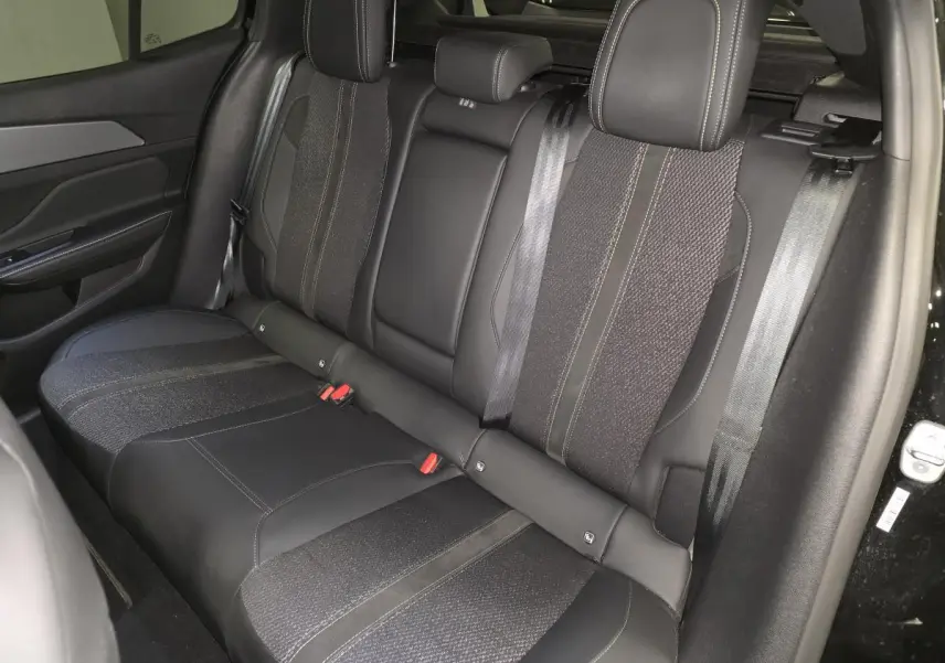 Vue intérieure côté droit de la banquette arrière noire en tissu et cuir du Peugeot 408 1.6 PHEV 2024 Berline GT