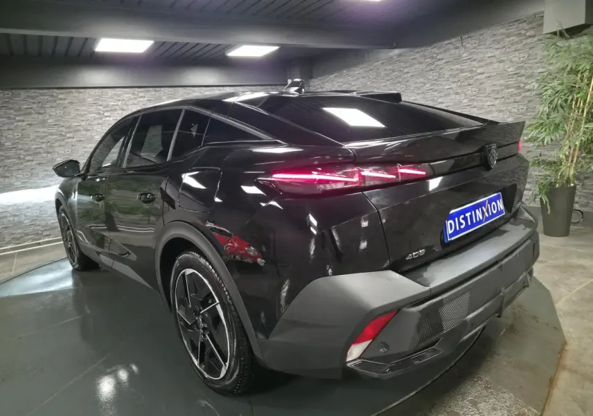 Vue 3/4 arrière droite d'une Peugeot 408 noire avec feux arrière LED dynamiques et jantes alliage 19 pouces.