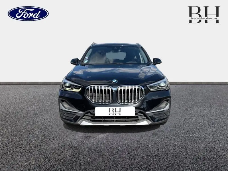 Vue avant d'un BMW X1 xDrive25eA 220ch xLine 2021 en noir saphir avec calandre imposante et phares LED distinctifs.