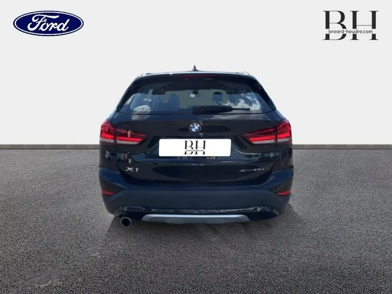 Vue arrière d'un BMW X1 xDrive25eA 2021 en noir Saphirschwarz avec feux LED et sortie d'échappement chromée visible.