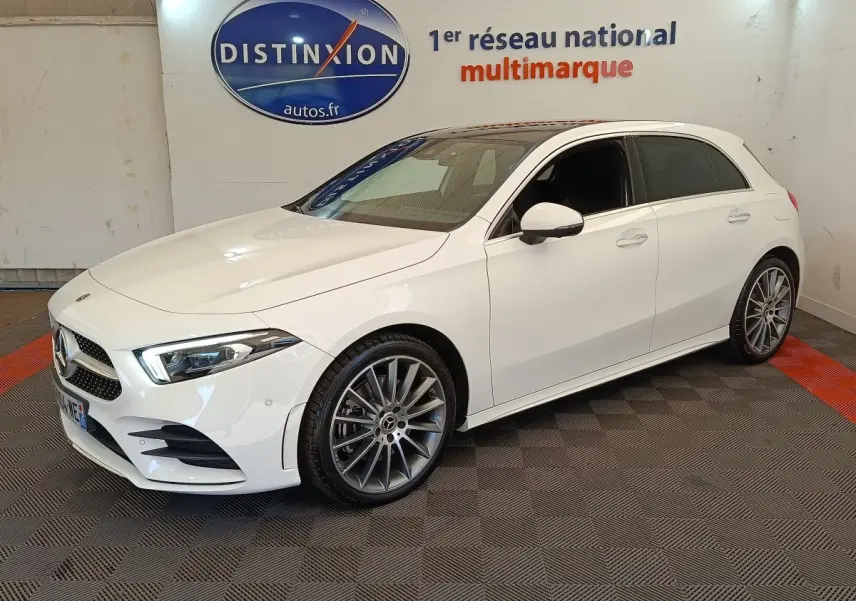 Mercedes Classe A 250 e AMG Line blanc vue 3/4 avant droit, jantes alliage et phares LED ellipsoïdaux visibles.