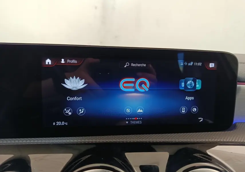 Écran tactile central affichant le menu EQ dans l'habitacle d'une Mercedes Classe A blanche, version AMG Line.
