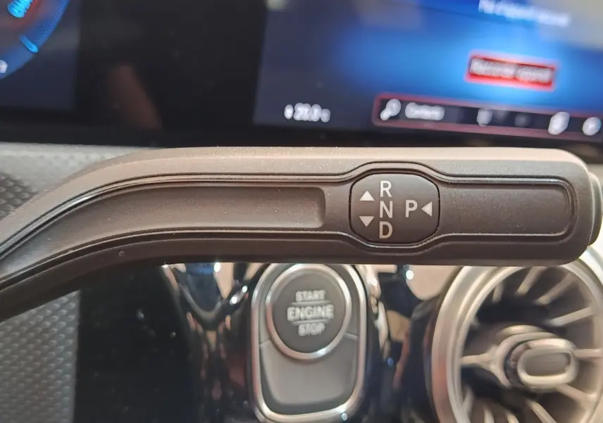 Le levier de vitesses automatique noir de la Mercedes Classe A 250 e AMG Line, intérieur avec bouton start/stop.