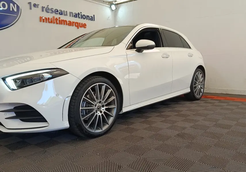 Mercedes Classe A 250 e AMG Line blanche vue de côté gauche avant, avec jantes alliage distinctives.