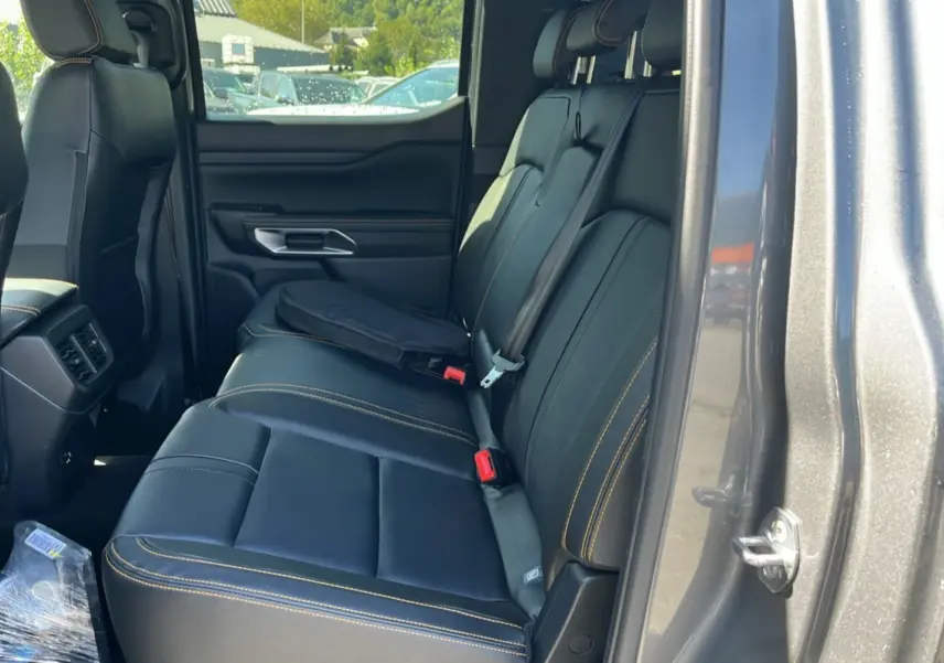 Vue côté droit de l'intérieur arrière du Ford Ranger gris carbone, sièges en cuir noir avec surpiqûres jaunes.