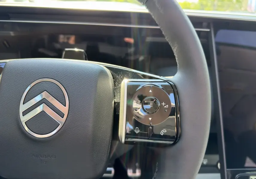 Gros plan sur le volant cuir multifonctions de la Citroën C5 Aircross New Hybrid 2026 avec commandes tactiles.