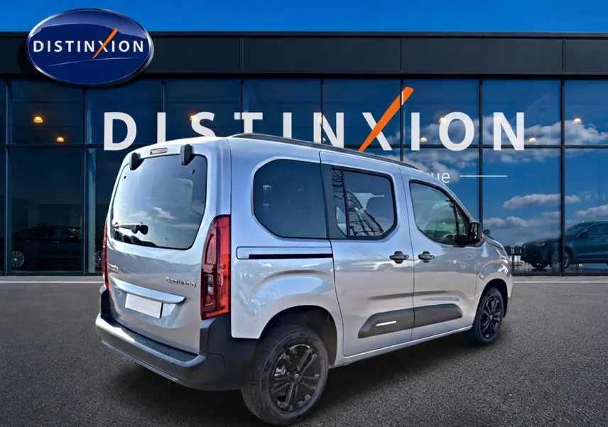 Vue 3/4 arrière droite du Citroën Berlingo Steel Grey 2026 avec barres de toit et jantes alu noires.