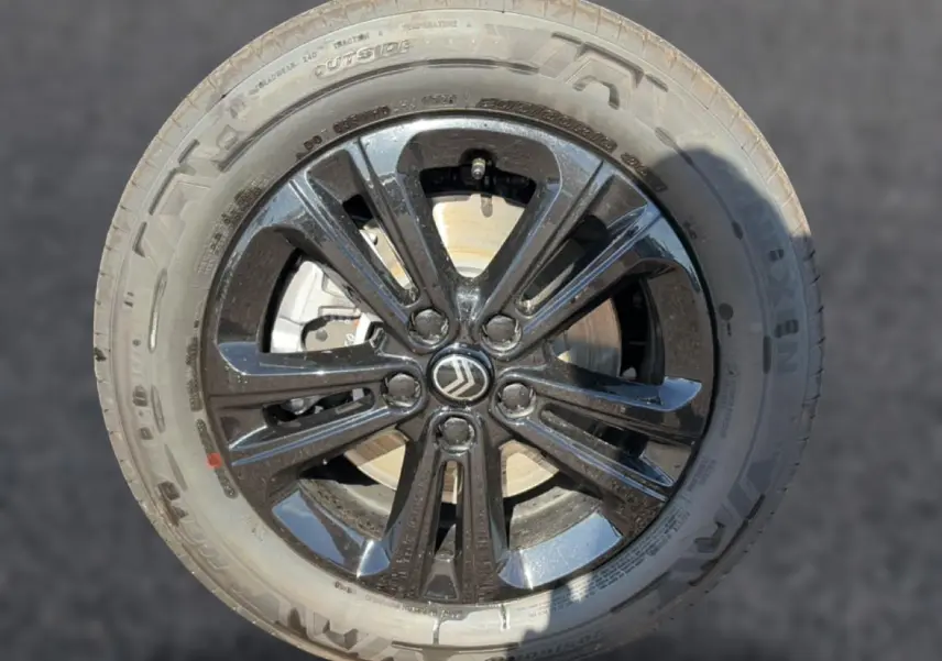 Gros plan sur la jante noire brillante avec logo Citroën au centre, montée sur pneu Nexen Steel Grey.