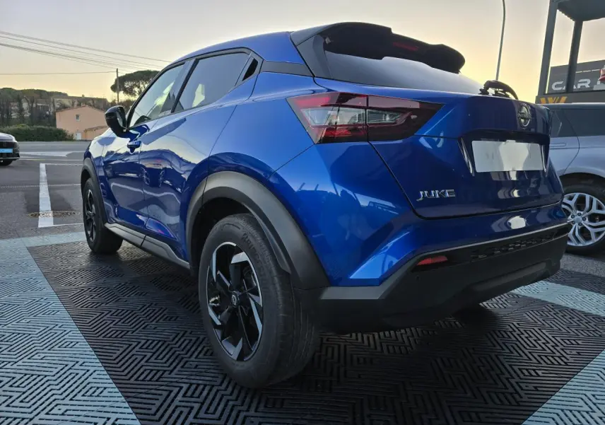 Vue 3/4 arrière droite du Nissan Juke II bleu magnetic avec jantes alliage noires et vitres teintées.