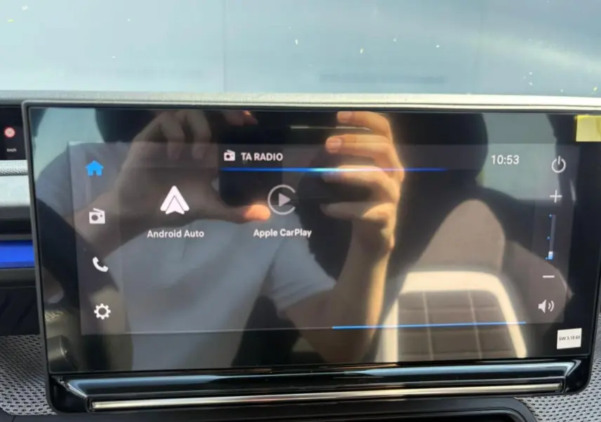 Écran tactile central de la Citroën C3 2025 affichant Android Auto et Apple CarPlay, reflet d'une personne visible.