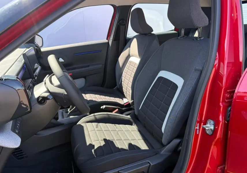 Vue intérieure côté gauche des sièges avant gris à motifs carrés d'une Citroën C3 rouge Elixir toit noir 2025
