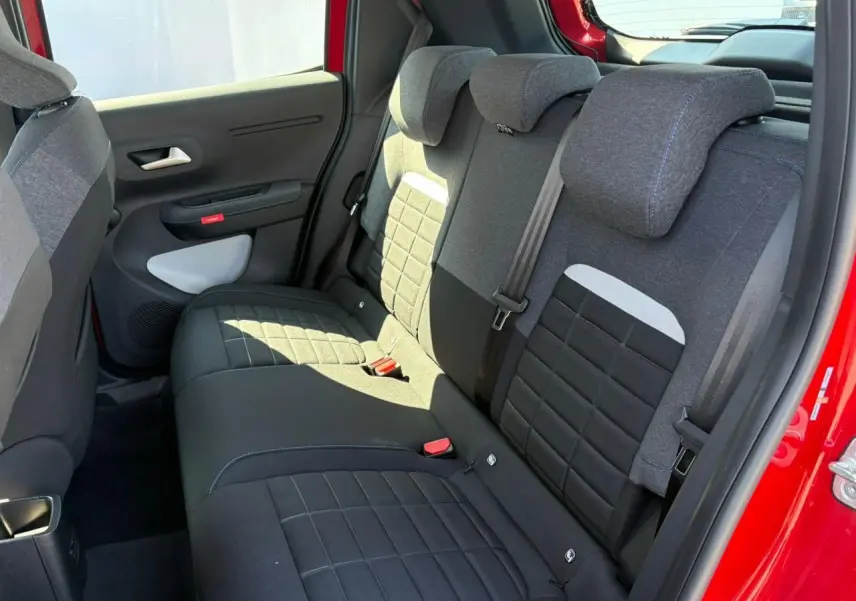 Banquette arrière en tissu gris et noir vue côté gauche d'une Citroën C3 Rouge Elixir avec porte ouverte.
