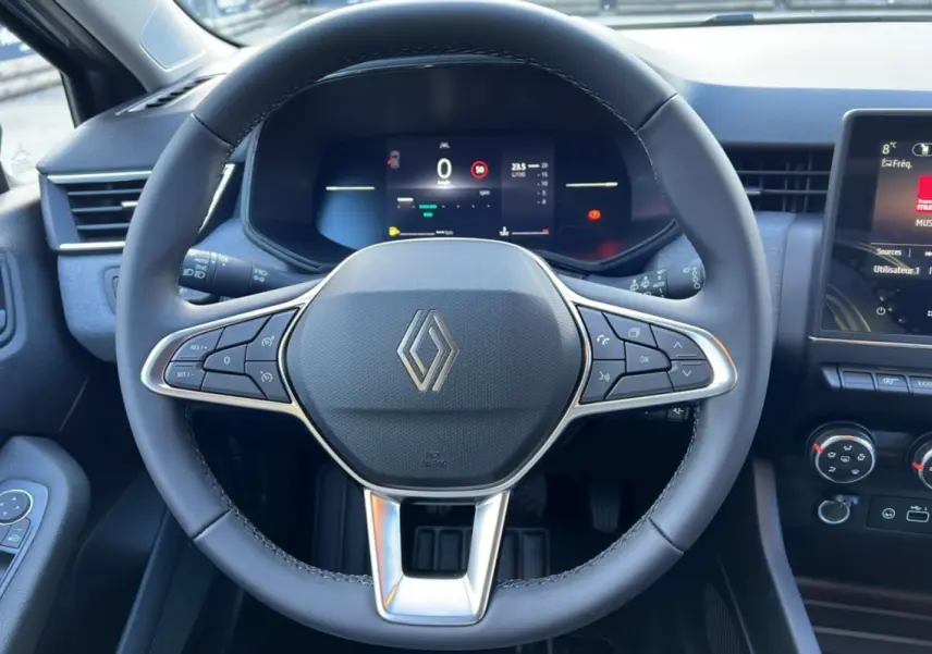 Vue frontale du volant de la Renault Clio 2025, tableau de bord numérique et écran central tactile visibles.