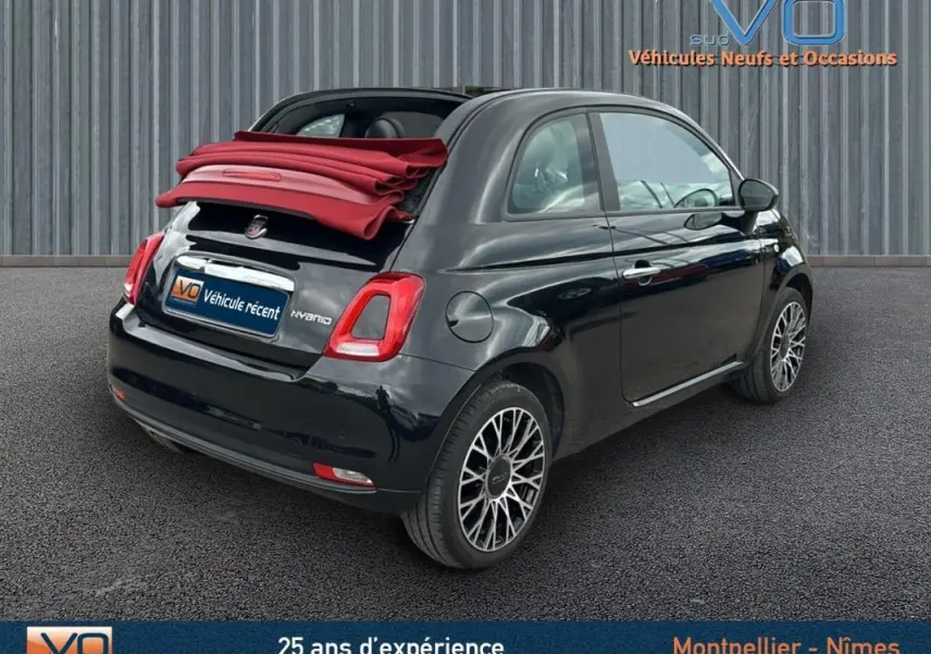 Fiat 500C noire vue 3/4 arrière droit avec toit rouge replié, jantes stylées et roue de secours visible