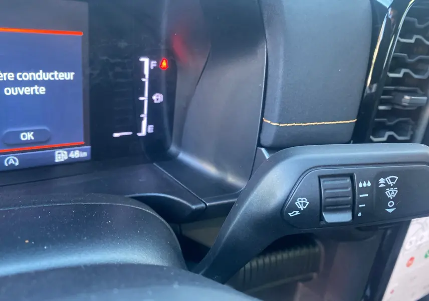 Détail du commodo d'essuie-glace avec affichage digital et message d'ouverture porte conducteur du Ford Ranger gris carbone 2025.