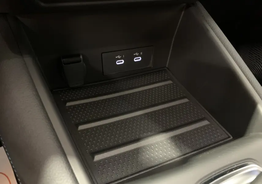 Gros plan sur la console centrale du Renault SYMBIOZ 2025, montrant deux ports USB-C et un espace de rangement noir.