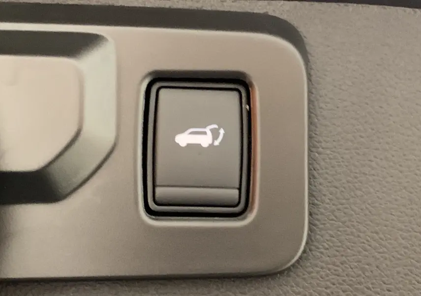 Bouton intérieur noir avec symbole blanc d'ouverture du hayon motorisé sur Renault Symbioz Bleu Iron.