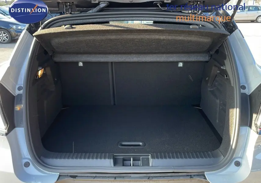 Coffre ouvert vu de l'arrière d'un Renault Captur gris Rafale métal avec toit noir, espace de chargement vide et propre.