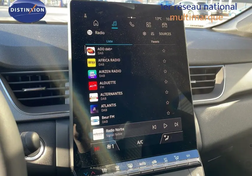 Écran tactile central du Renault Captur E-Tech gris rafale, affichant les stations radio dans l'habitacle moderne.