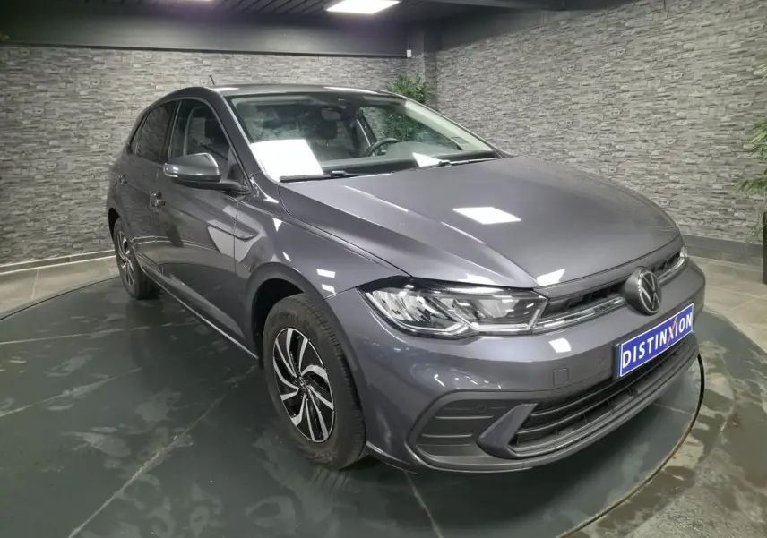 Volkswagen Polo gris métallisé vue 3/4 avant droit avec jantes alliage et calandre chromée.
