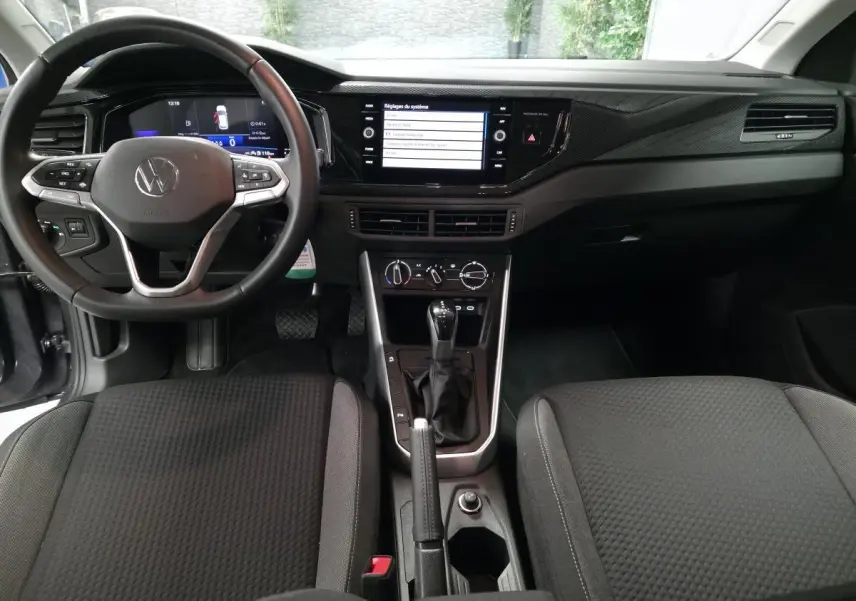 Vue intérieure avant de la Volkswagen Polo gris, tableau de bord avec écran tactile et volant multifonction cuir.