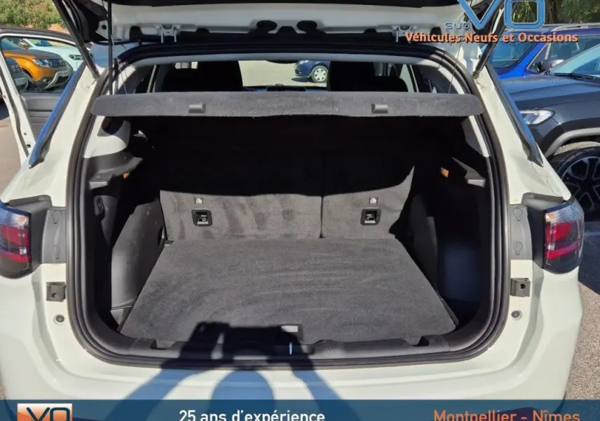 Coffre ouvert d'un Jeep Compass blanc 2023, vue arrière montrant l'espace de chargement vide et la plage arrière.