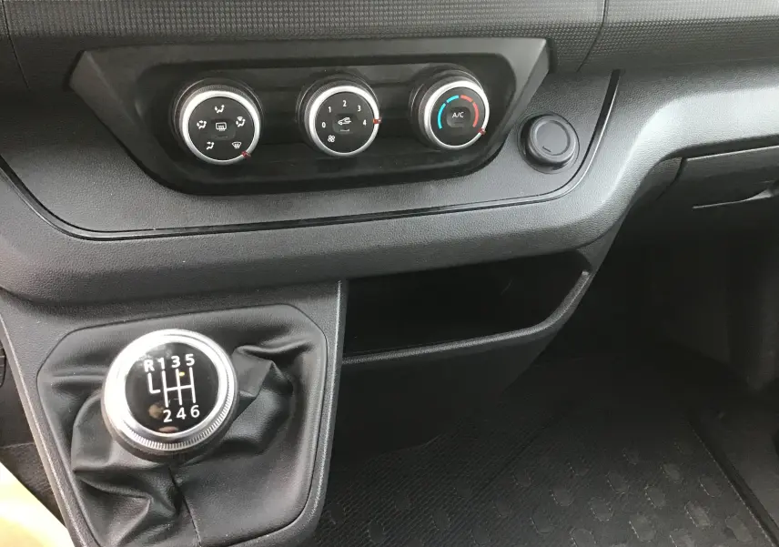Gros plan sur la console centrale du Renault Trafic Combi 2023, avec levier de vitesses manuel et commandes de climatisation.