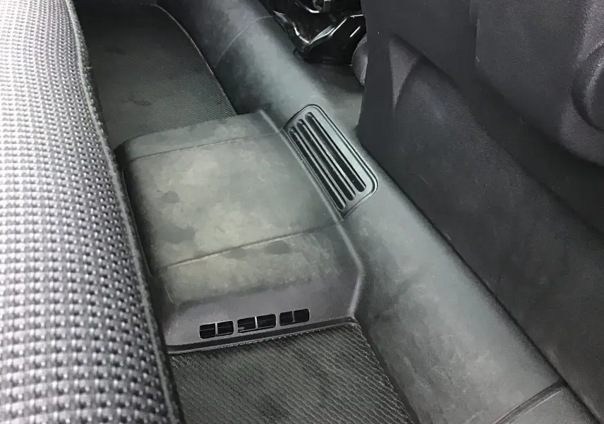 Vue rapprochée du plancher arrière côté gauche du Renault Trafic Combi gris clair, montrant les grilles d’aération au sol.