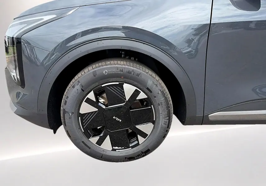 Gros plan sur la roue avant gauche du KIA Sportage gris eclipse, mettant en valeur la jante alu au design moderne.