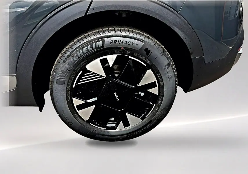 Gros plan sur la roue arrière droite gris eclipse du KIA SPORTAGE 1.6 hybride 239 avec jante alu noire et argent.