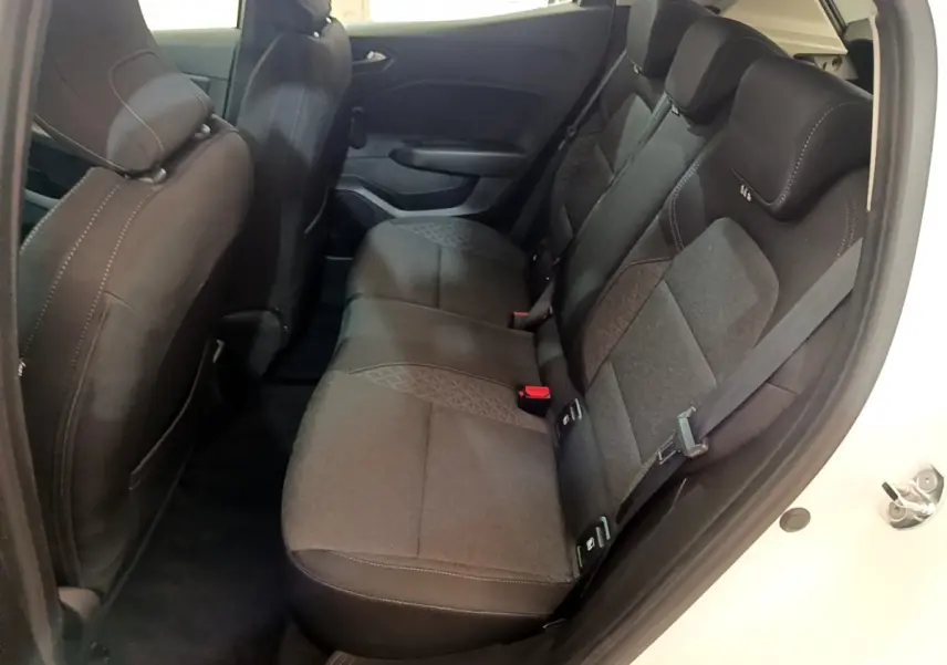 Vue latérale droite de l'habitacle arrière de la Renault Clio Business blanche, sièges tissu noir avec surpiqûres contrastées.