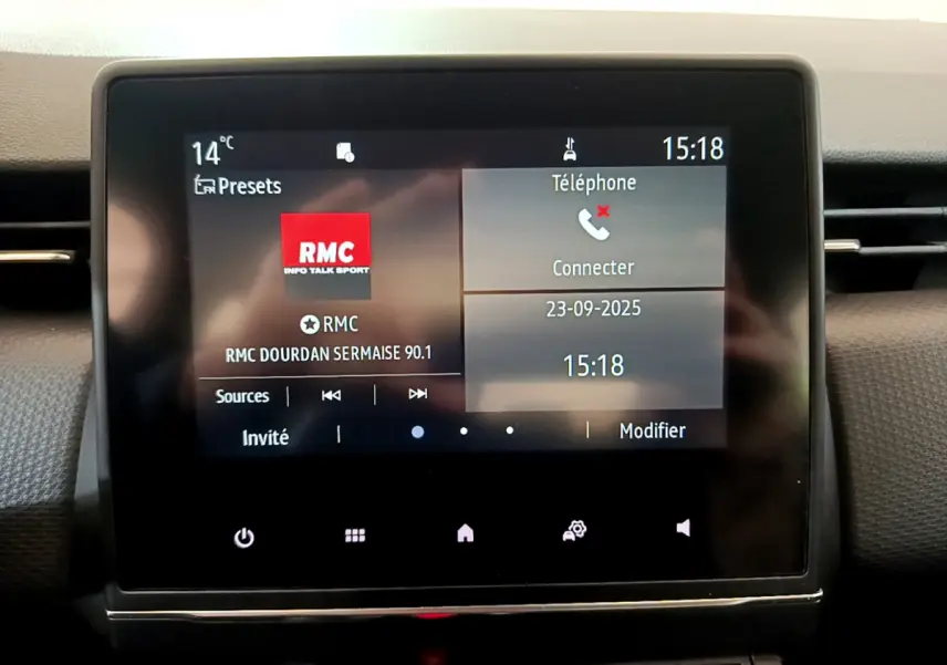 Écran tactile central de la Renault Clio Business blanc 2021 affichant la radio RMC et options téléphone à 15h18.