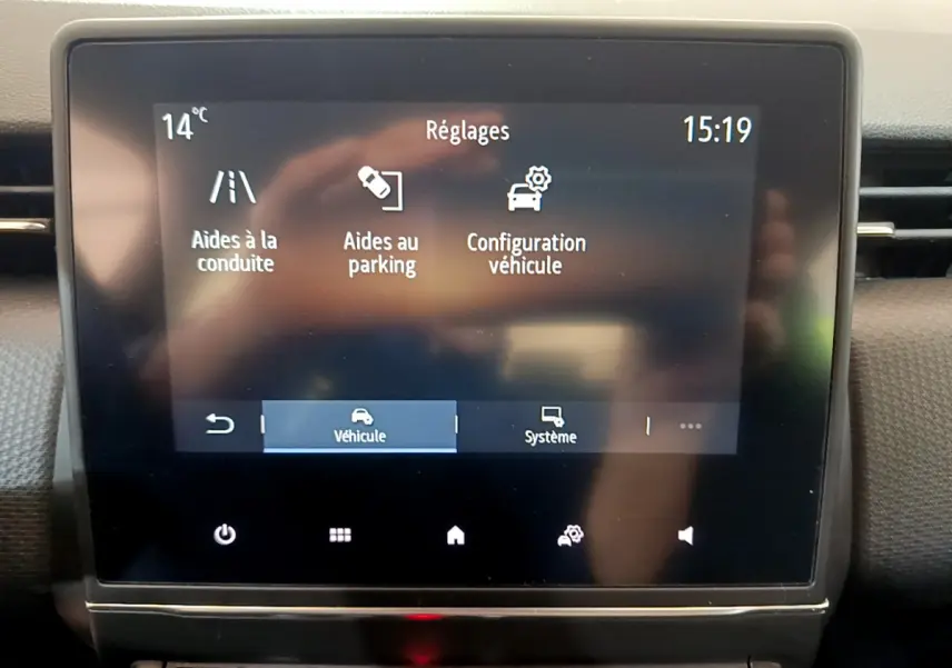Écran tactile central de la Renault Clio Business blanc 2021 affichant les réglages d'aides à la conduite et au parking.