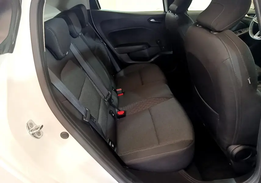 Vue intérieure arrière droite de la Renault Clio Business blanche, sièges tissu gris foncé avec ceinture de sécurité visible.