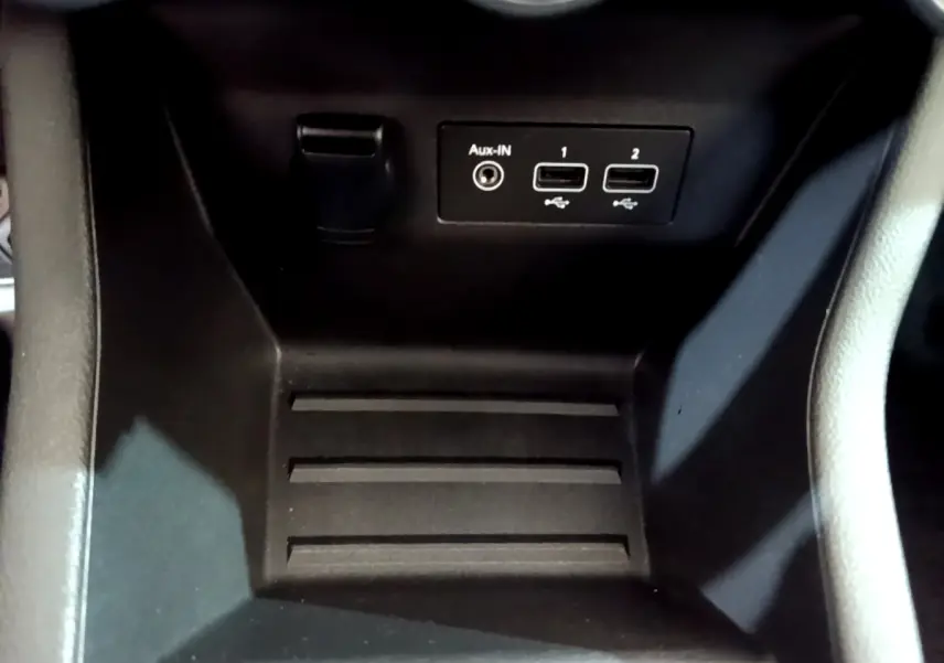 Gros plan sur la console centrale noire de la Renault Clio Business avec ports USB et entrée Aux-In visibles.