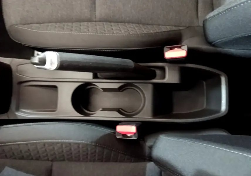 Vue plongeante sur la console centrale noire avec frein à main et porte-gobelets de la Renault Clio Business blanche 2021