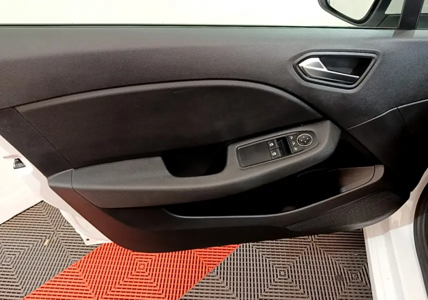 Porte côté gauche ouverte de la Renault Clio Business blanche 2021, avec commandes des vitres et rétroviseurs visibles.