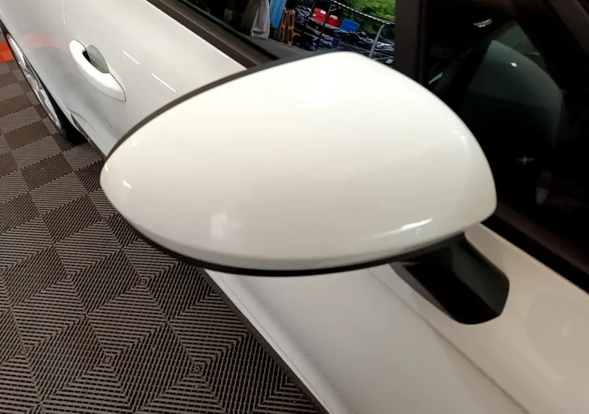 Rétroviseur côté droit blanc en gros plan sur Renault Clio Business 2021, avec porte et poignée visibles.