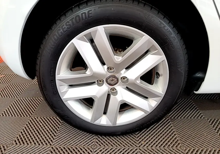 Gros plan sur la roue avant droite blanche d'une Renault Clio Business 2021 avec jante alliage et pneu Bridgestone.