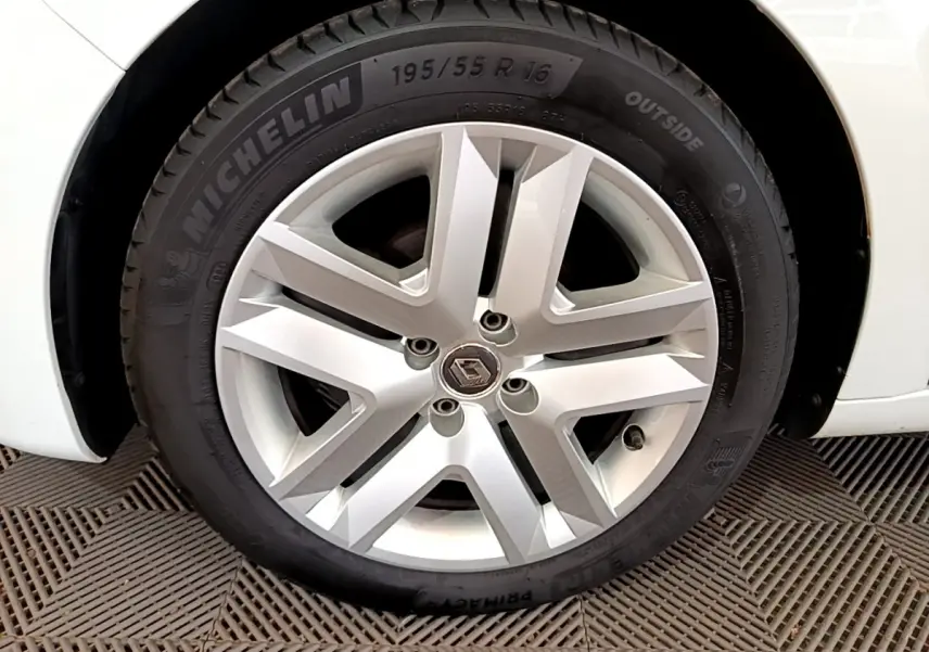 Gros plan sur la roue arrière droite d'une Renault Clio Business blanche de 2021, avec partie de la carrosserie visible.