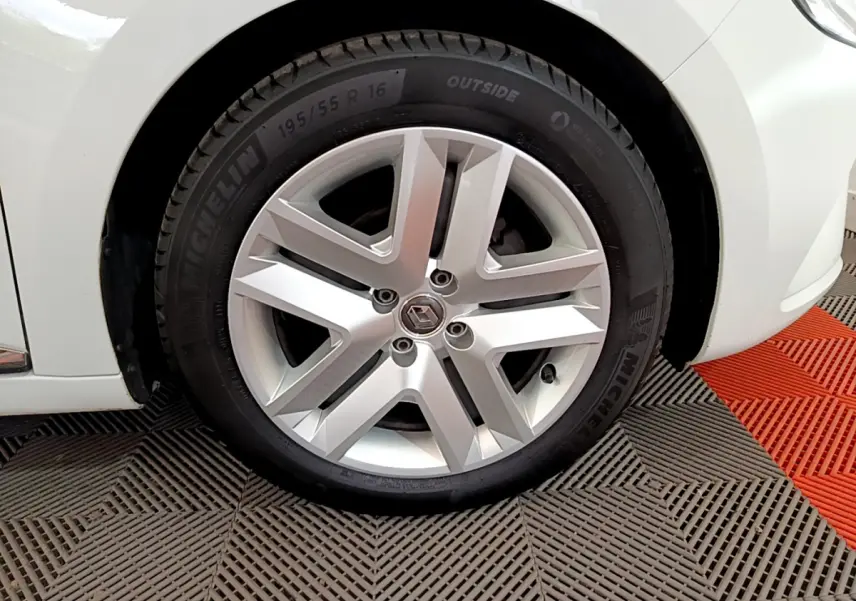 Gros plan sur la roue avant droite de la Renault Clio Business blanche, mettant en valeur la jante alliage et le pneu Michelin.