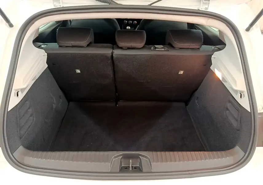 Coffre ouvert vu de l'arrière d'une Renault Clio Business blanche, montrant la banquette arrière et l'espace de chargement.