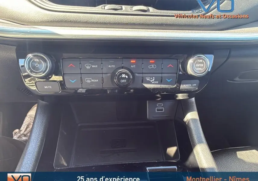 Vue rapprochée de la console centrale du Jeep Compass gris 2023, mettant en valeur les commandes de climatisation et ports USB.